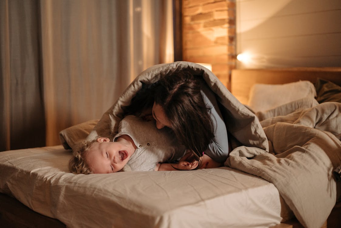 Mother and Child Playing on Bed