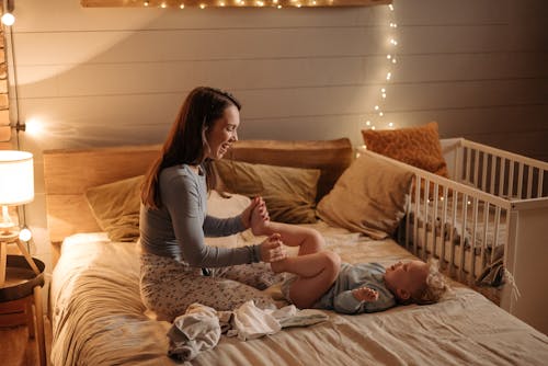 Free Woman Playing With Her Child in a Bedroom  Stock Photo