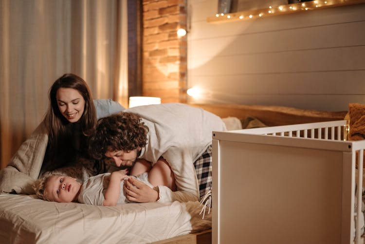 Parents Spending Time With Their Child In Bed