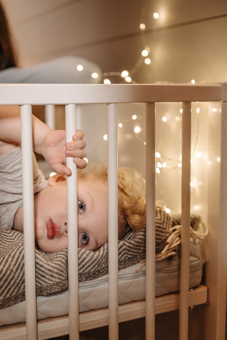 Baby Lying In A White Crib