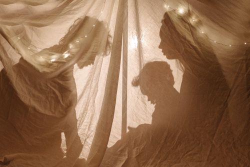 Free Silhouettes of a family playing inside a decorated tent with soft lights. Stock Photo