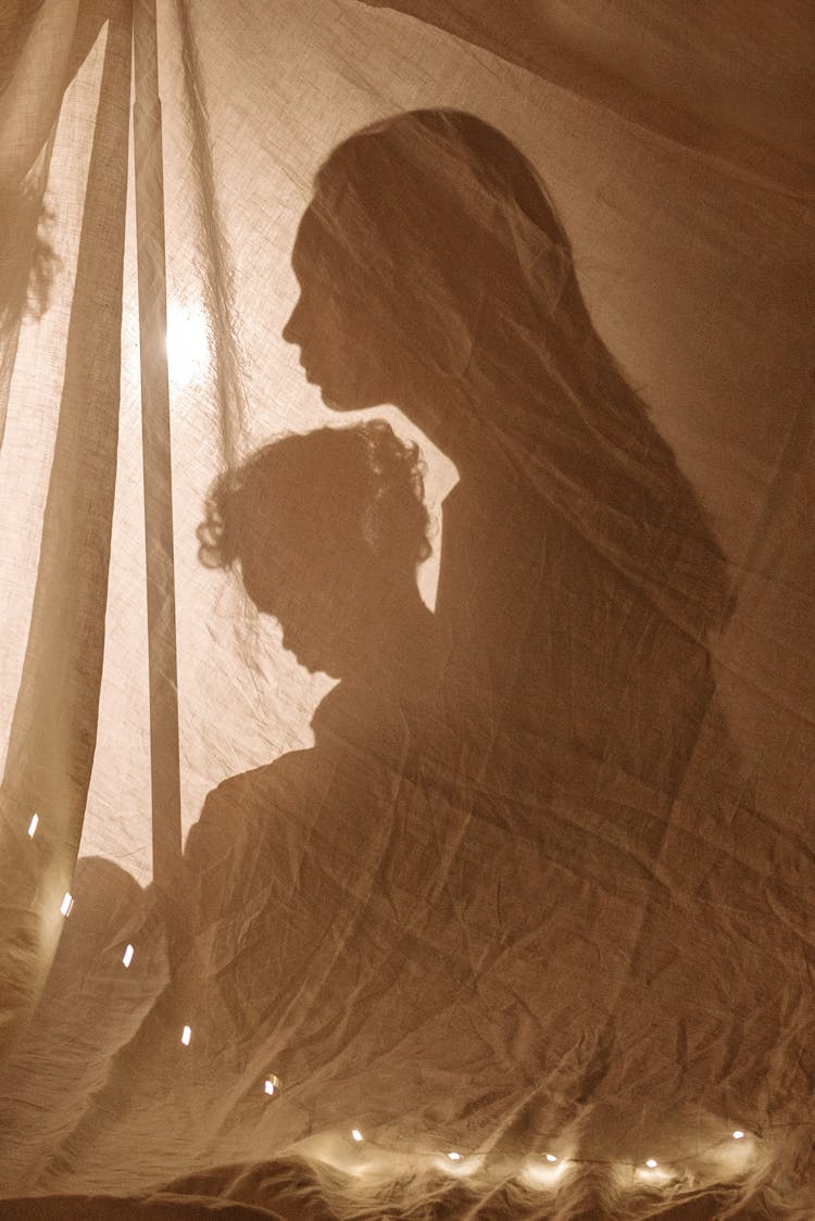 Silhouette Of Mother And Child Behind A Textile