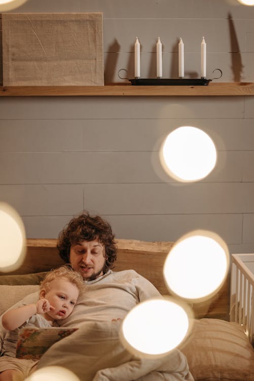 Free Man Reading Bedtime Story to a Boy Stock Photo