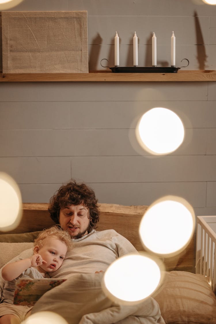 Man Reading Bedtime Story To A Boy