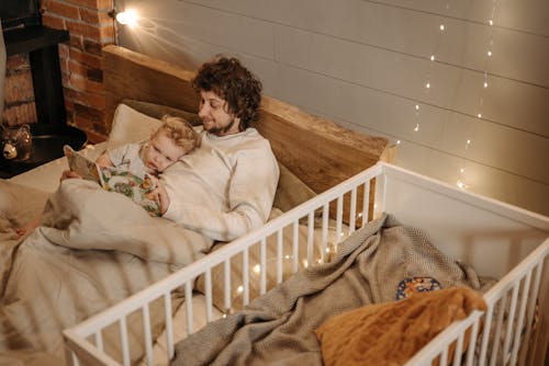 Free A Father Reading a Book to His Kid  Stock Photo