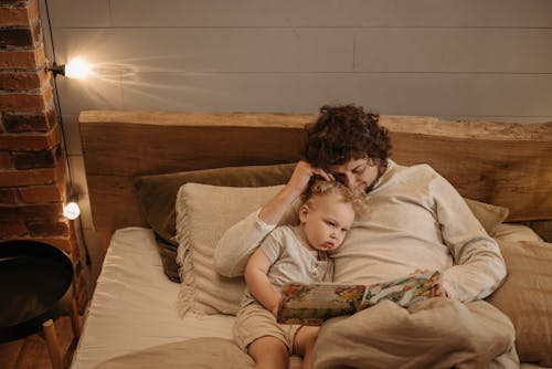 Free Man Reading Bedtime Story to His Child Stock Photo