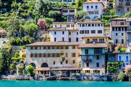 Scenic view of hillside Italian village, colorful houses by Lake Lugano.