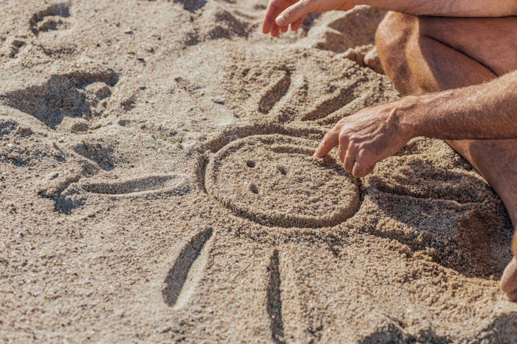 A Person Drawing On The Sand