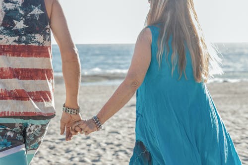 Free A Couple Walking on the Shore Stock Photo