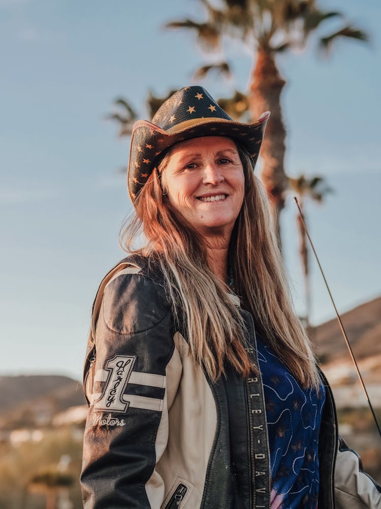 Woman In Cowboy Hat And Leather Jacket Smiling