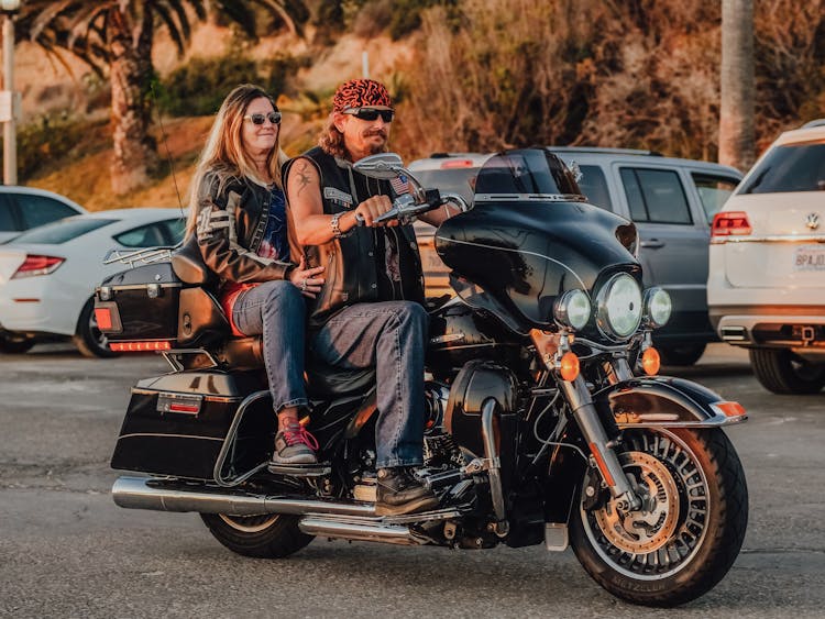 A Couple Riding A Harley Davidson Touring