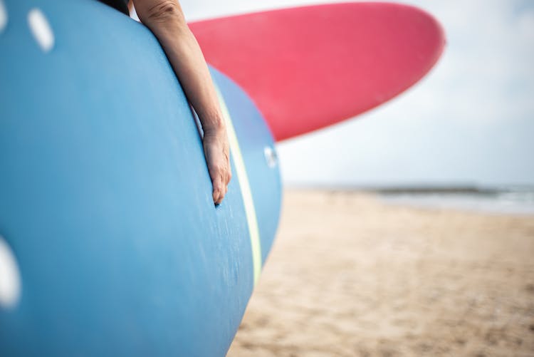 Person Carrying A Surfboard