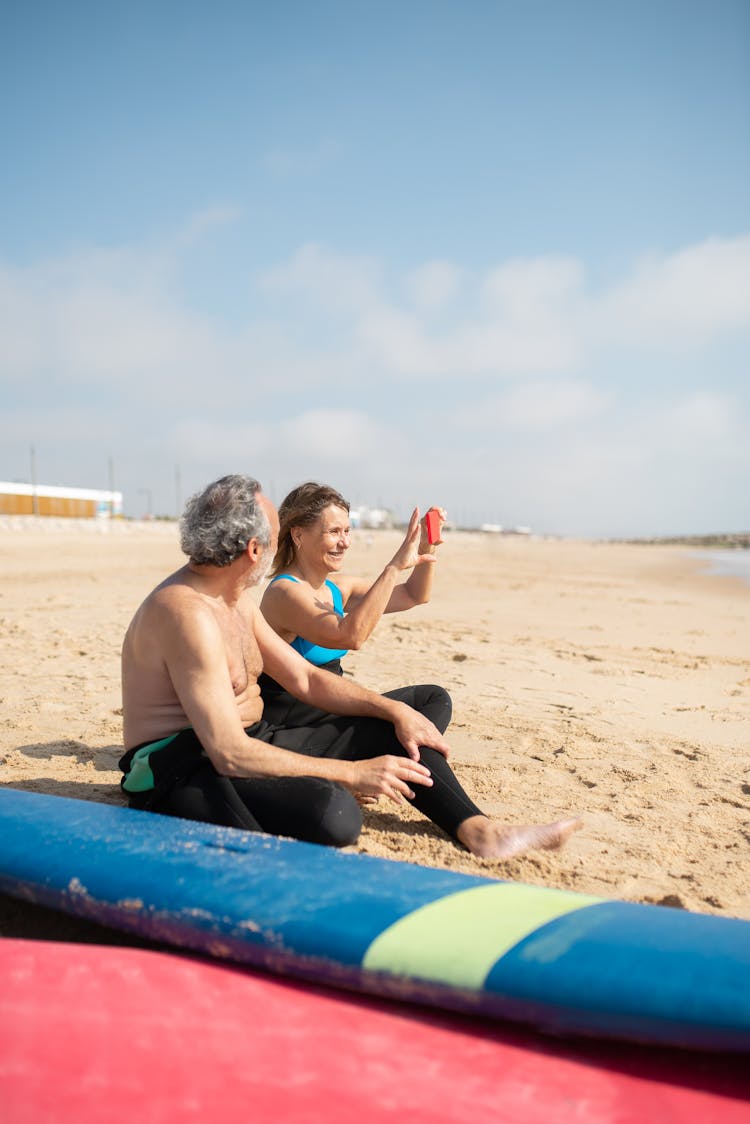 Surfers Sitting On Beach