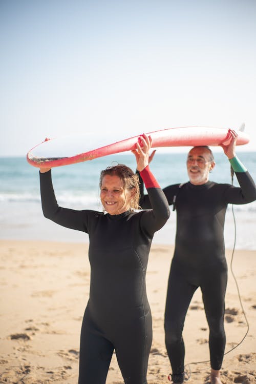 A Couple Carrying a Surfboard 