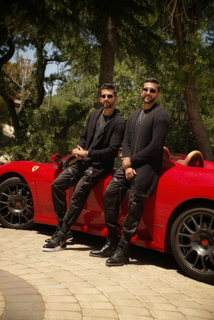 Men Leaning On Red Top Down Car