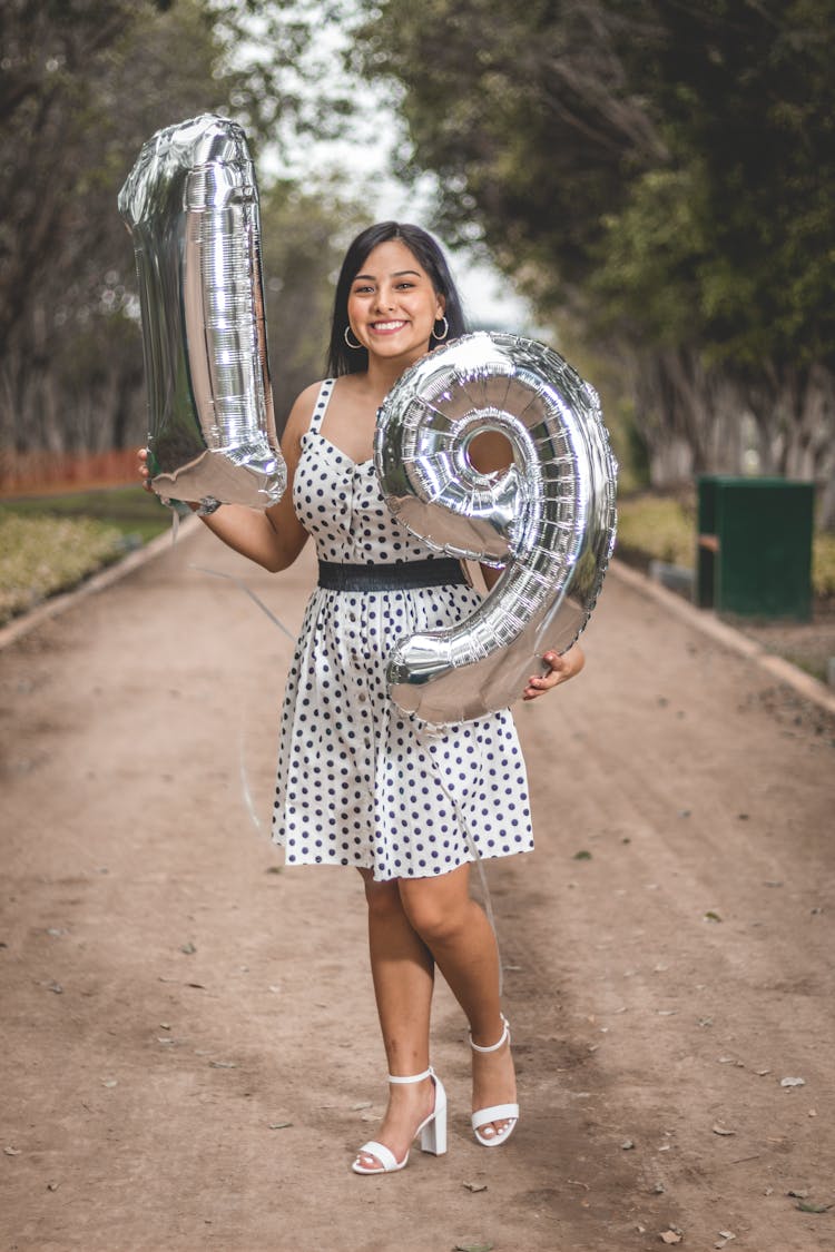 Young Woman Posing With Gray Inflatable Balloons