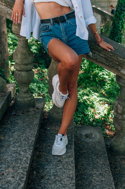 A Woman Wearing White Shoes and Denim Shorts Free Stock Photo