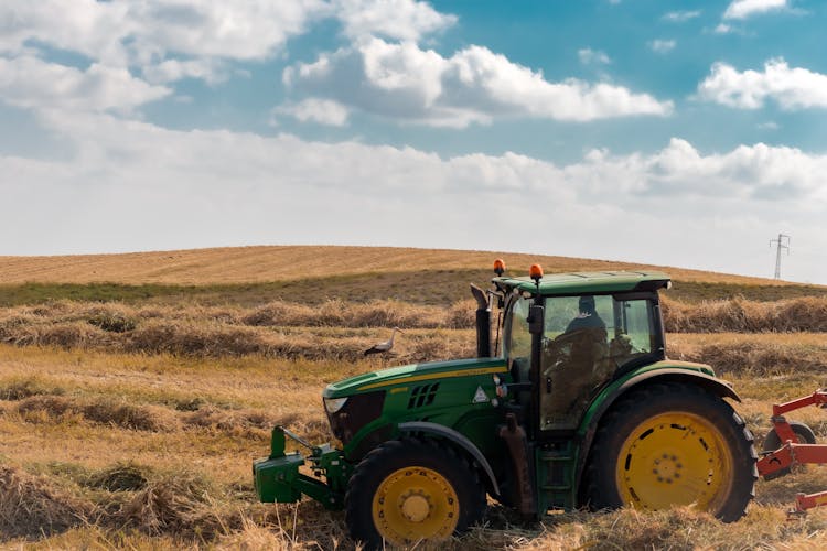 Green Tractor On Hayfield