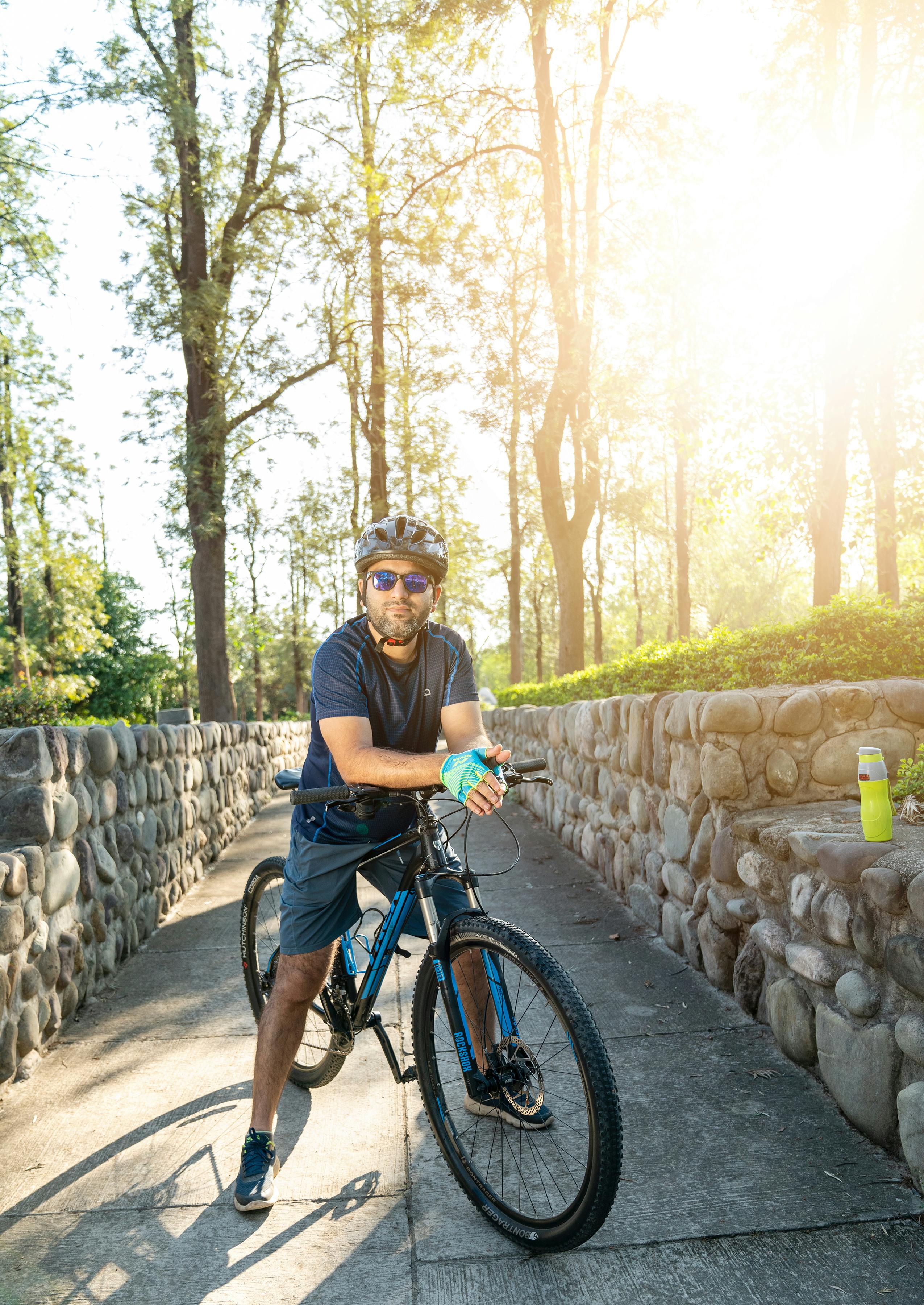 A Man Wearing a Helmet Riding a Bicycle · Free Stock Photo