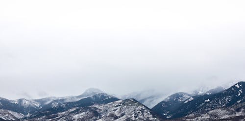 Montaña Cubierta De Nieve Bajo Nubes Blancas