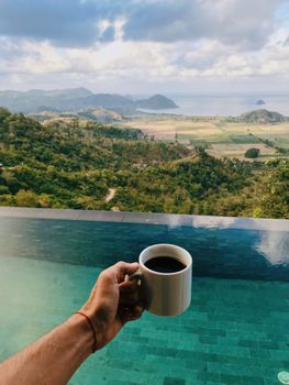 Relaxing coffee by an infinity pool with a breathtaking view of Indonesia's landscape.