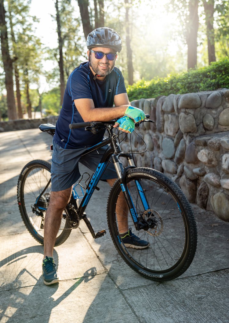 A Man In Helmet And Fingerless Gloves Riding A Bike