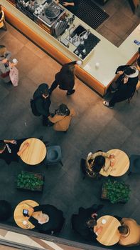Aerial view of a busy café interior with people enjoying coffee and conversations.
