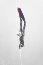 Unrecognizable diver swimming down rope in water