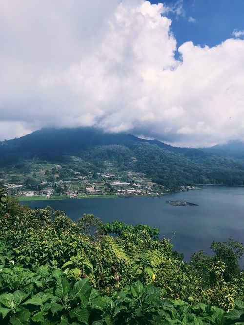 Free Breathtaking view of a lake with mountainous backdrop in Bali, surrounded by lush greenery. Stock Photo