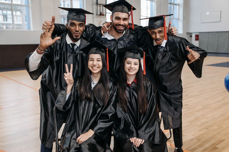 Group of African American graduates in cap and gown celebrating