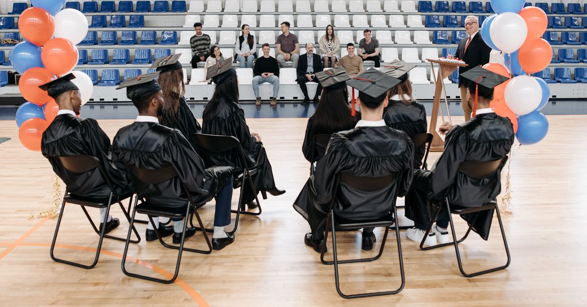 Photo of Graduates Sitting on a Folding Chair · Free Stock Photo