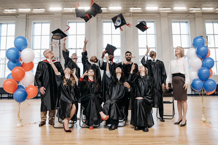 Group Of People Wearing Black Academic Dress Throwing Academic Caps