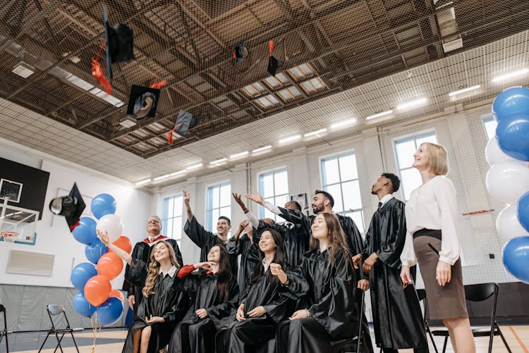 Group Of People Wearing Black Academic Dress Throwing Academic Caps