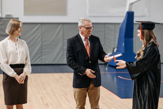Graduation ceremony with a graduate receiving a diploma in a gymnasium. Celebrating success.