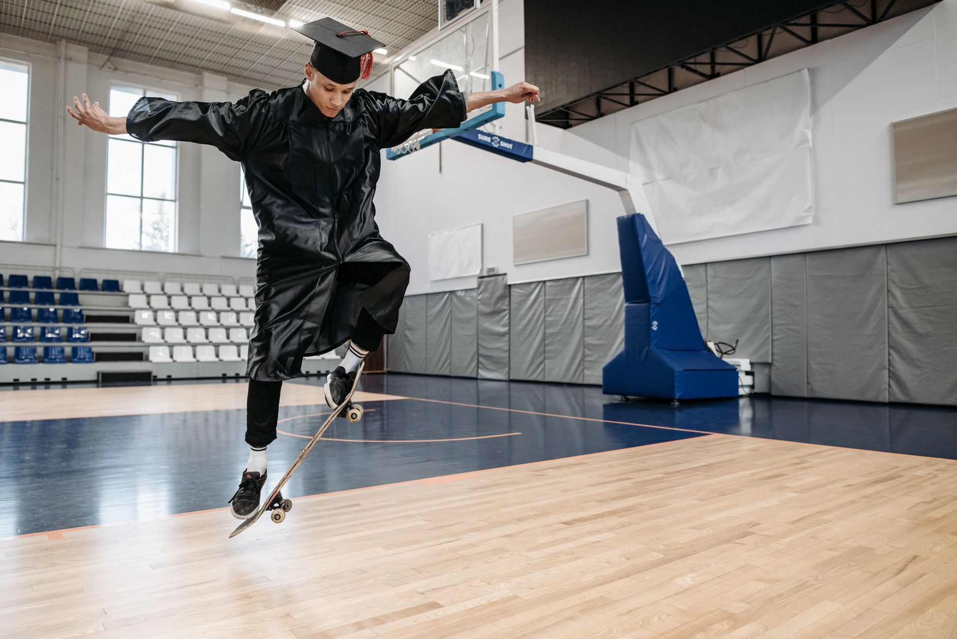 A collegiate wide receiver performing explosive medicine ball throws beside a football practice field