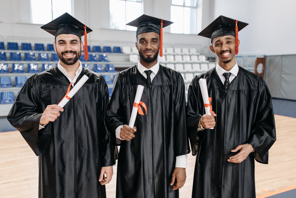 Free Men in Academic Dress Standing while Holding Diplomat Stock Photo