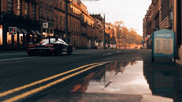 A sleek black supercar parked on an empty urban street, showcasing luxury and speed.