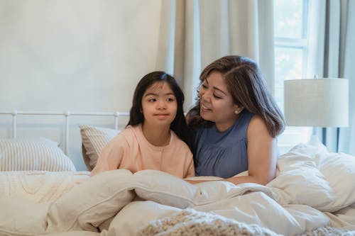 A Mother and Daughter Sitting on the Bed
