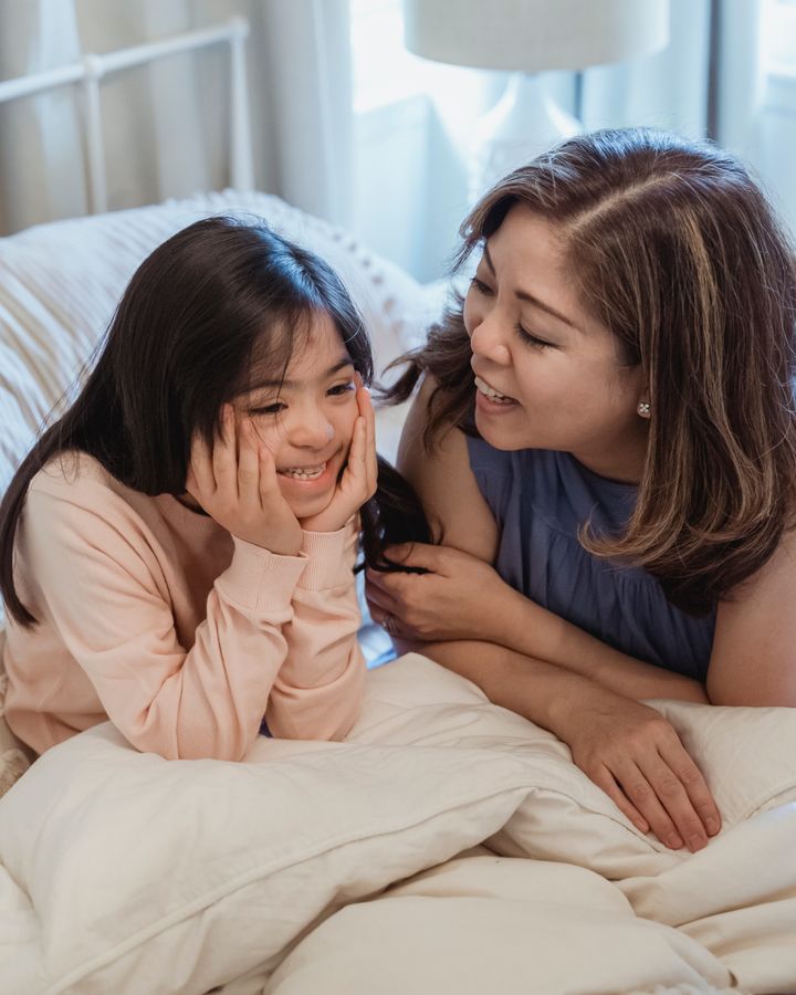 Mother and daughter with Down syndrome sharing a joyful moment at home