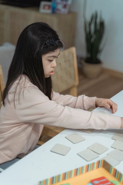 Free Child focused on a memory card game at home, developing concentration skills. Stock Photo