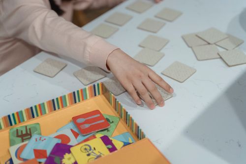 Free A child engages in a fun memory matching card game, showcasing focus and concentration. Stock Photo
