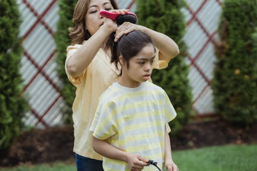 Mother brushing her Daughter's Hair 