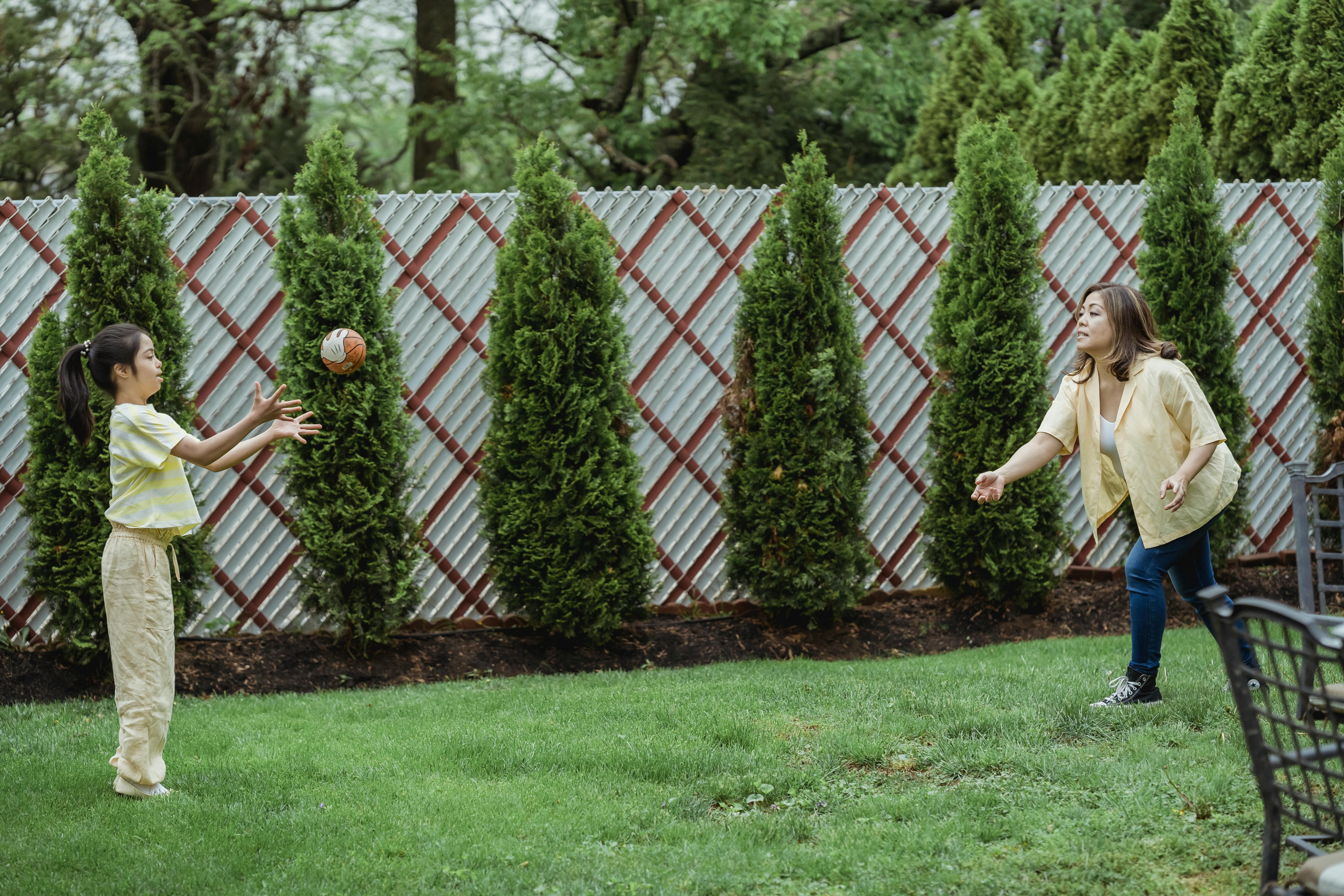 family playing safely in a fenced backyard - fence installation round rock