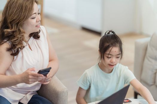 A mother and daughter enjoying a tech moment together at home, fostering connection and learning.