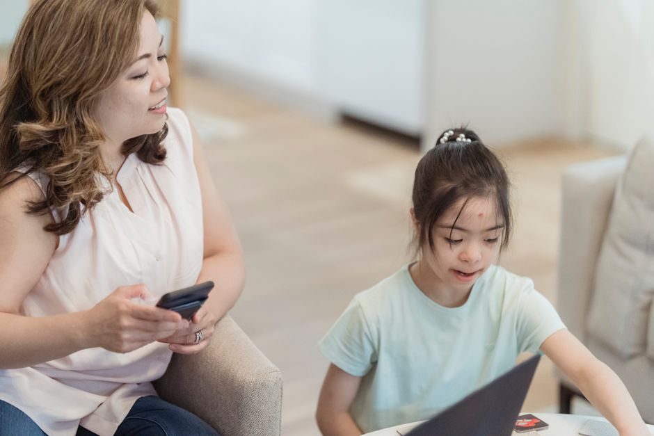 A mother and daughter enjoying a tech moment together at home, fostering connection and learning.