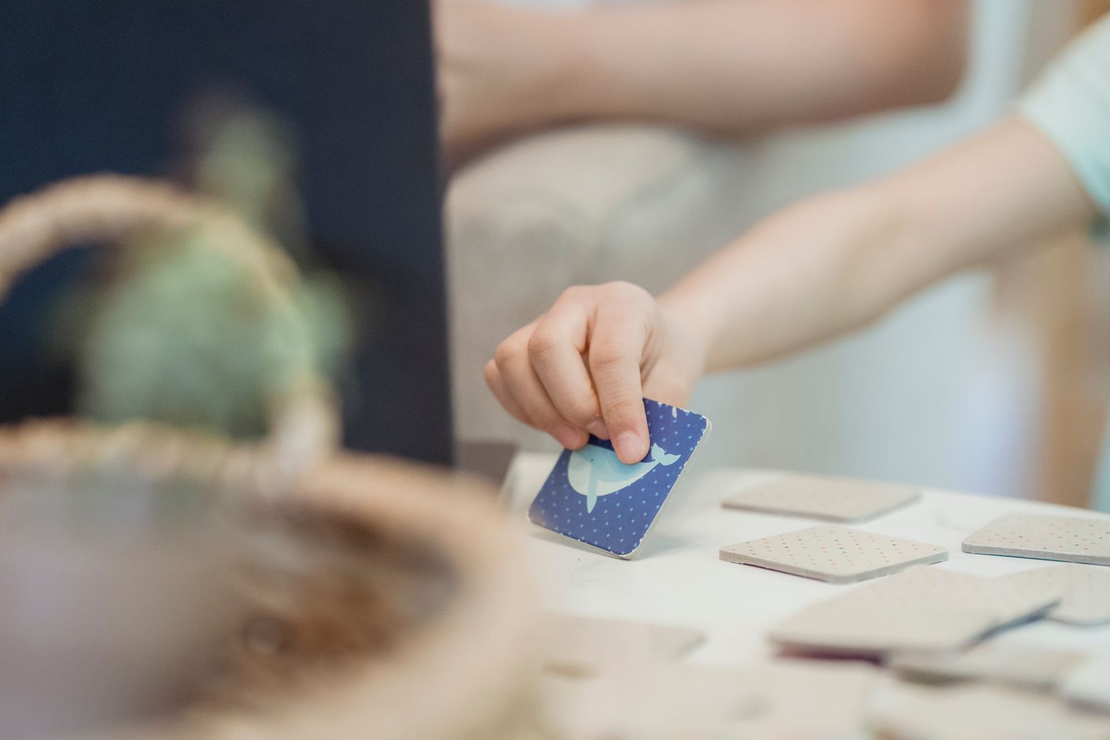 Mão de criança segurando uma carta durante uma atividade lúdica