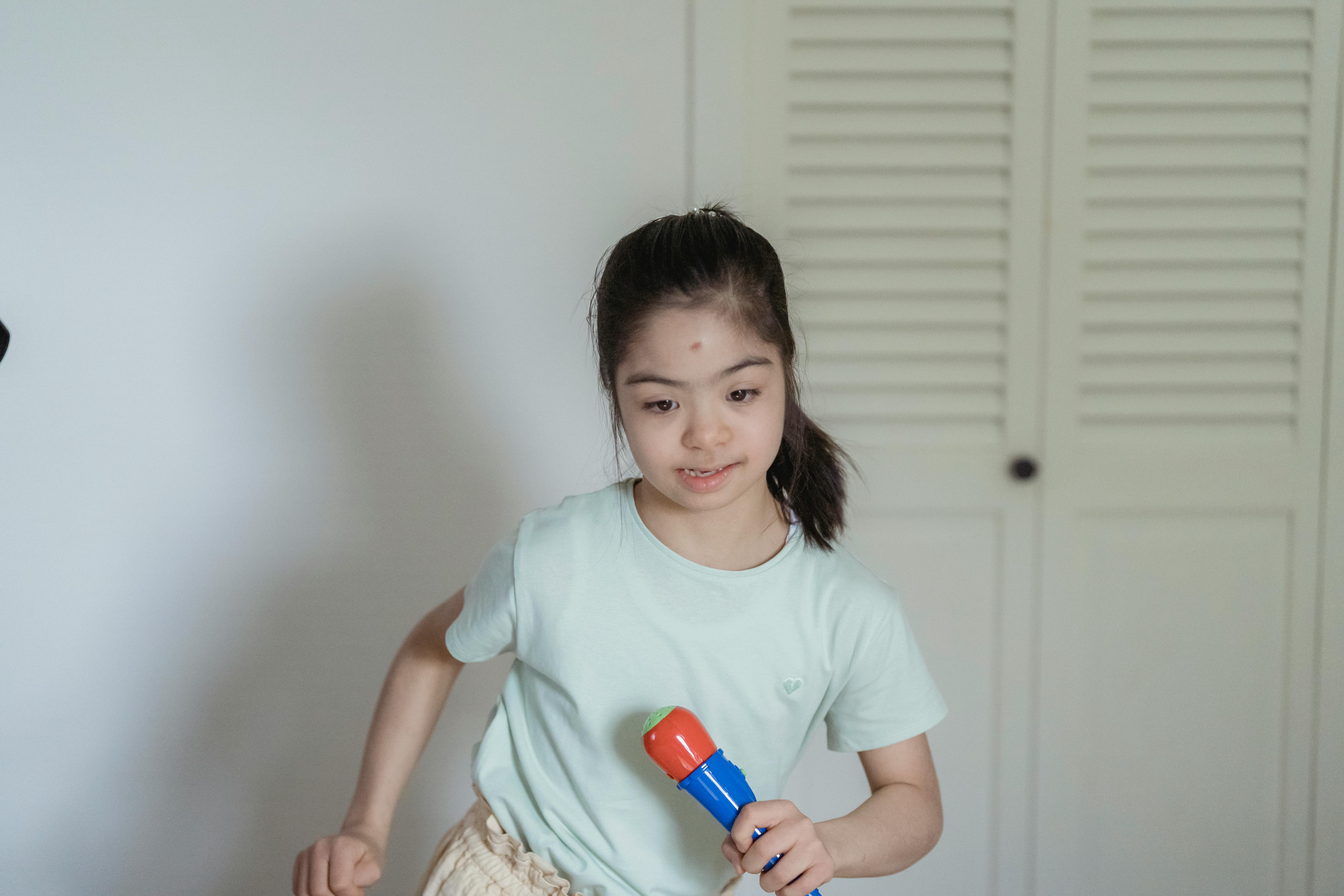 a young girl in white shirt holding her microphone