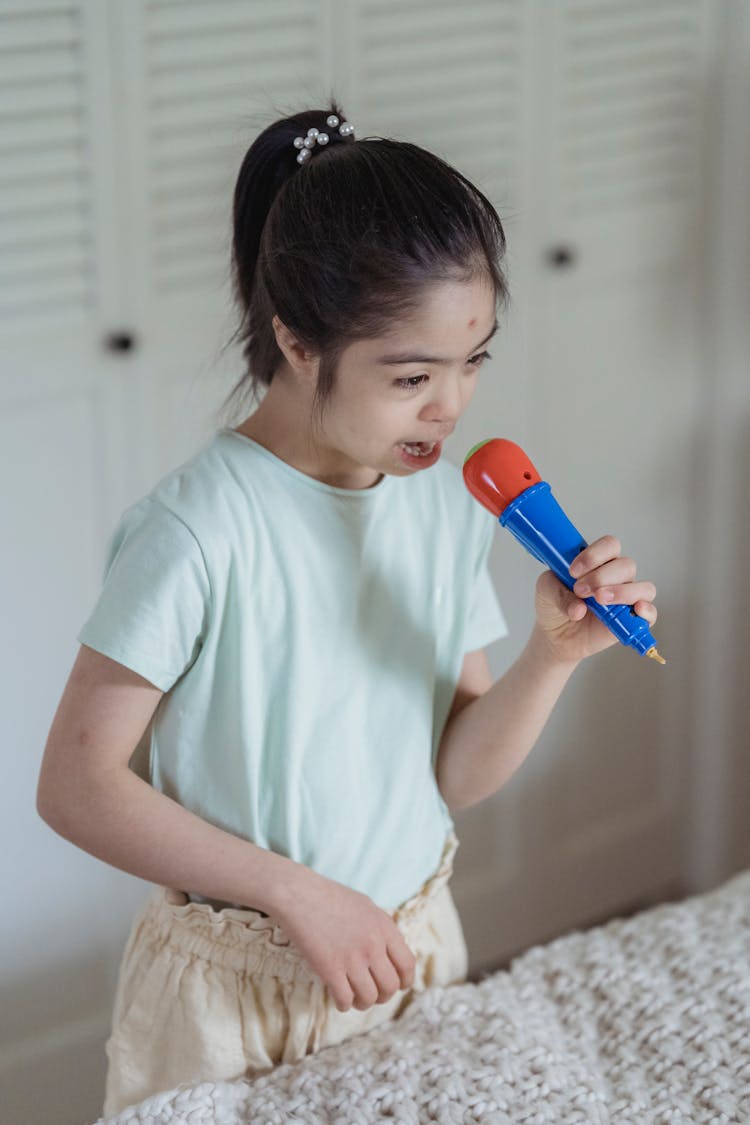 A Young Girl Singing While Holding Her Microphone