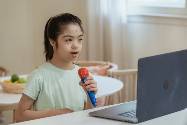 A Young Girl Holding Her Toy Microphone While Singing