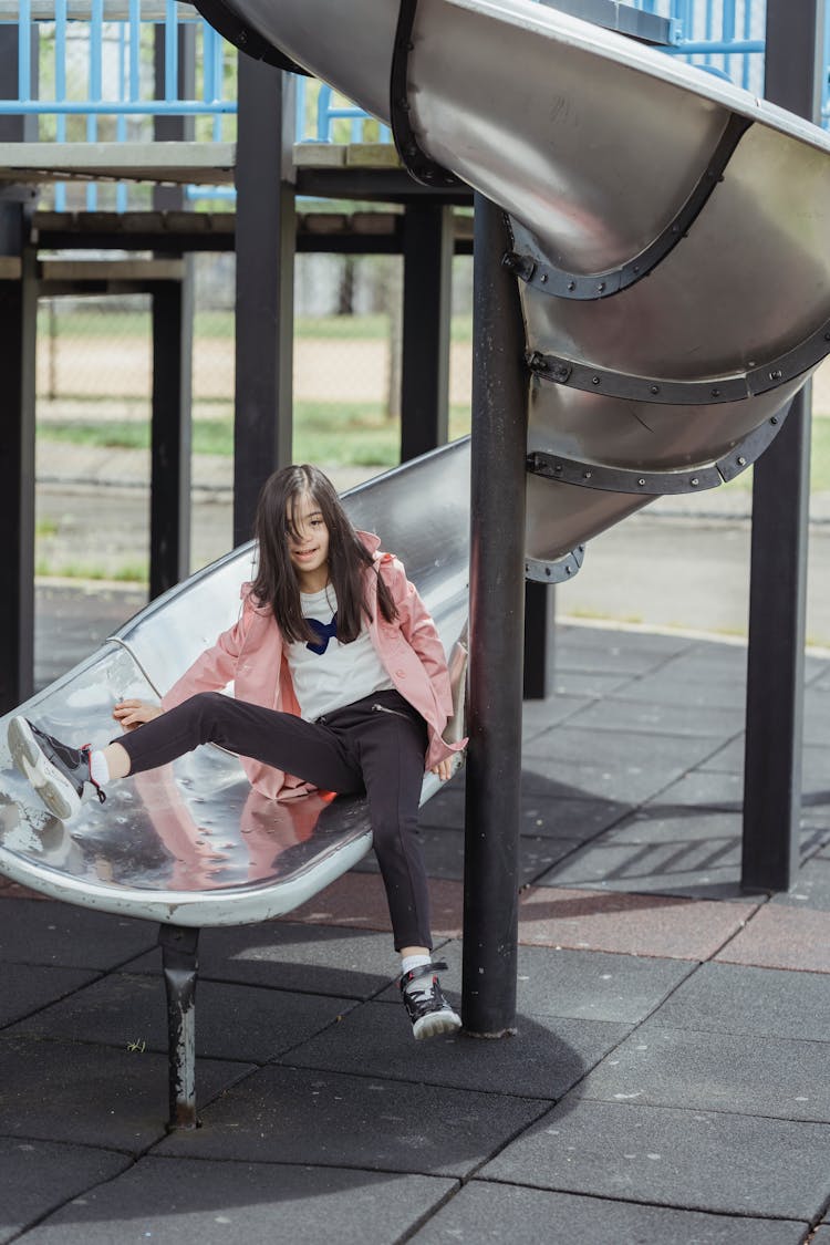 A Girl Sitting On A Slide